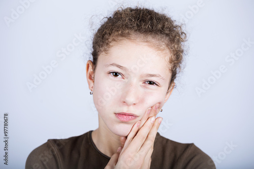 Portrait of a Young girl with toothache over white background.Child toothache with sensitive tooth ache problem touching on face the part with pain.