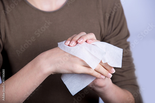 Child Hyigiene.Little girl cleaning her hands with a wet baby wipe isolated on a white background.