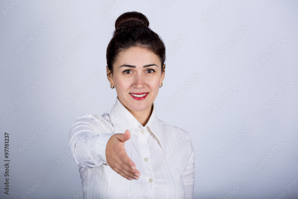 Business woman with hand extended to handshake - isolated over white.Young woman introducing herself extended to handshake. Business woman with hand extended to handshake - isolated over white.Young woman introducing herself extended to handshake.