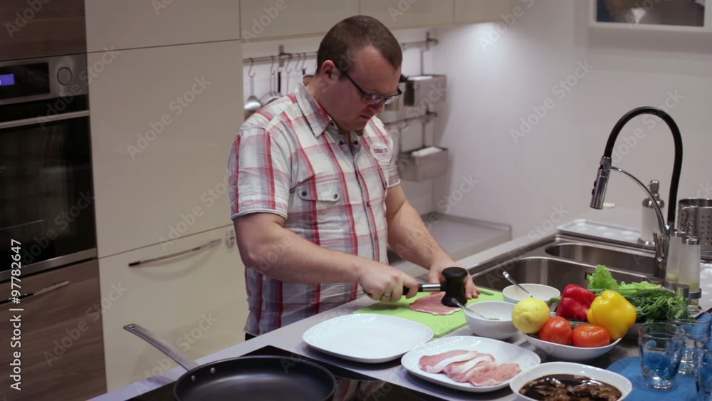 Man beats hammer pork in the kitchen Man beats hammer pork in the kitchen