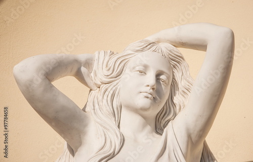 Detail of garden sculpture depicts a dreamy young woman