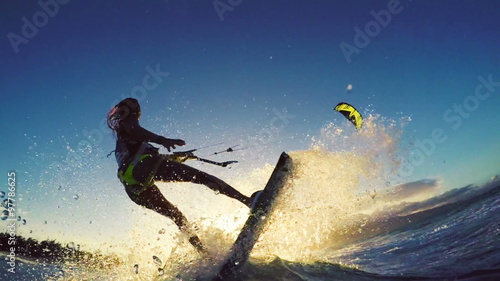 Extreme Kitesurfing at Sunset. Summer Ocean Sport in Slow Motion. Girl Kite Surfing in Bikini 