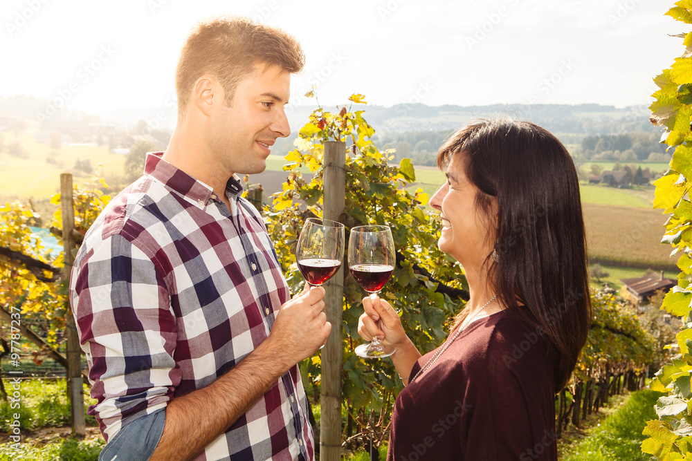 Fototapeta premium Couple tasting wine in a vineyard