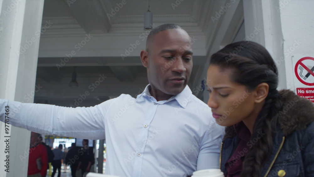Attractive mixed ethnicity couple on city street using smartphone for directions. Attractive mixed ethnicity couple on city street using smartphone for directions.