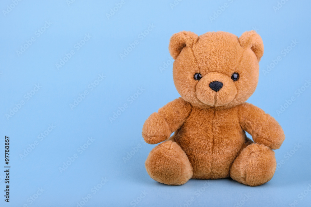 Toy teddy bear on blue background with copy space