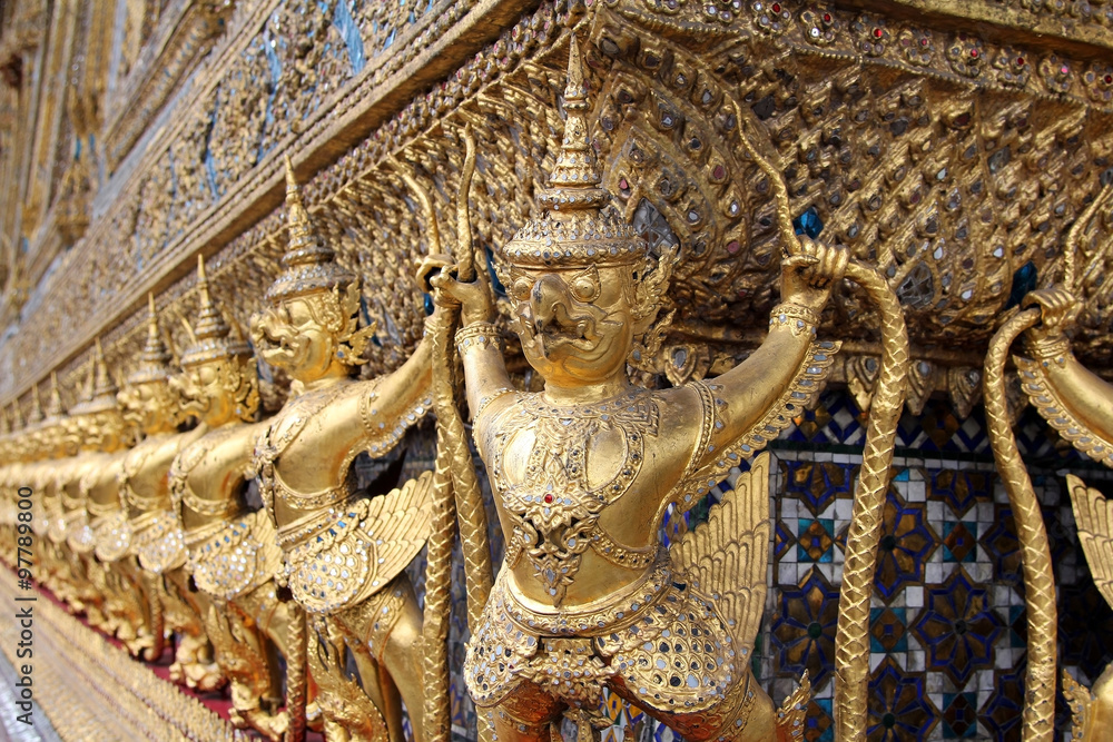 The statues of Krut battling naga serpent, a Thai Buddhist adaptation of Garuda in Wat Phra Kaeo temple, Bangkok, Thailand.