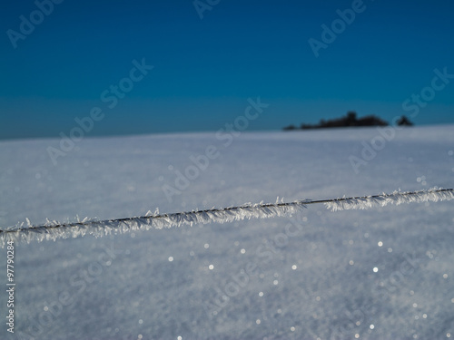 Eiskristalle auf einem Zaun verzaubern Winterlandschaft