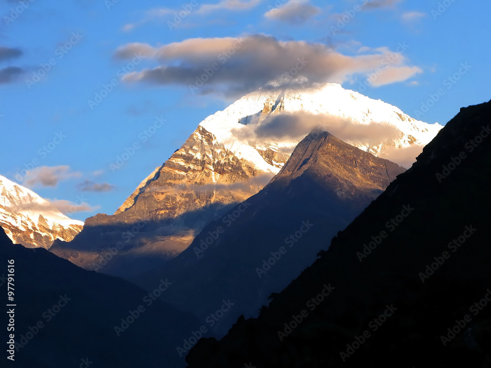 Golden Snow Mountain sunrise and clouds in the Himalayas
