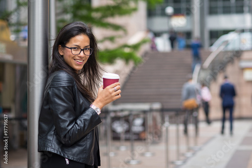 Smiling portrait of young mixed race businesswoman portrait outdoors in Canary Wharf in London.
