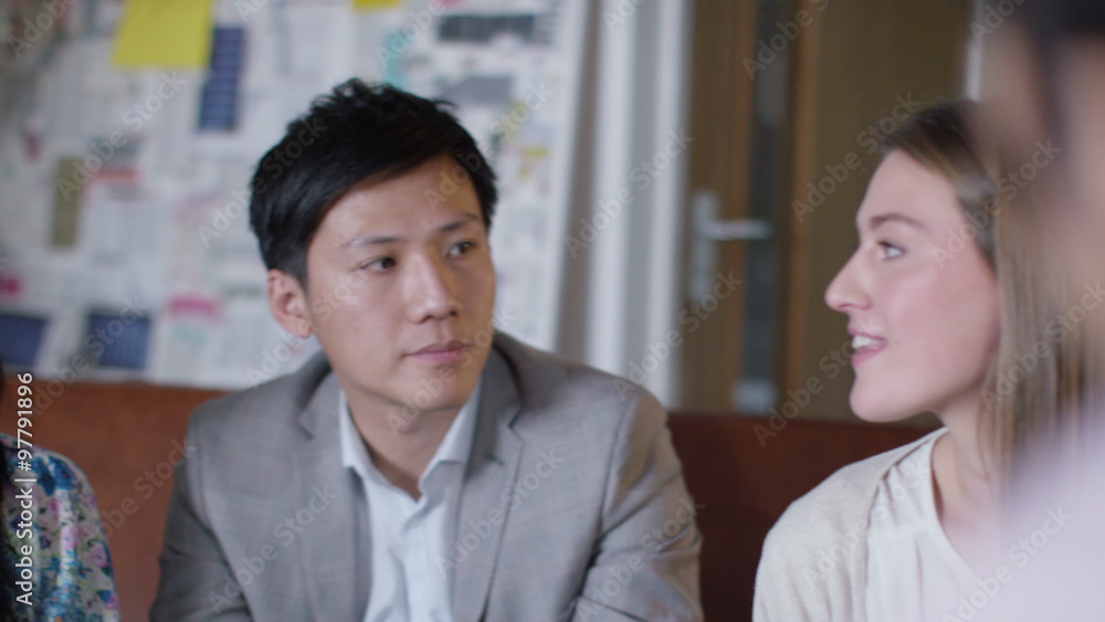 Attractive mixed ethnicity business team in discussion in office meeting Attractive mixed ethnicity business team in discussion in office meeting