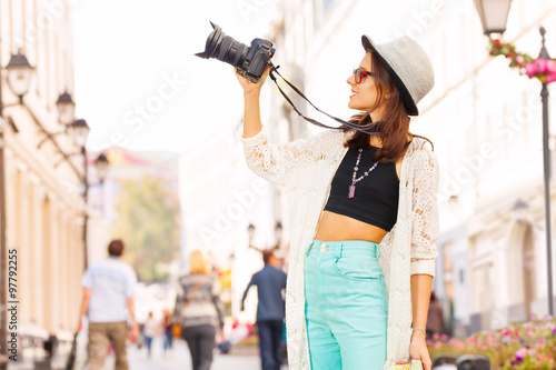 Girl wearing sunglasses shooting with camera