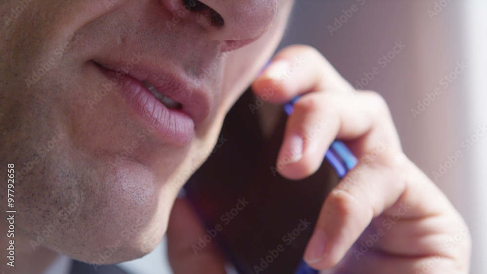 Extreme close-up of businessman talking on mobile phone. Extreme close-up of businessman talking on mobile phone.
