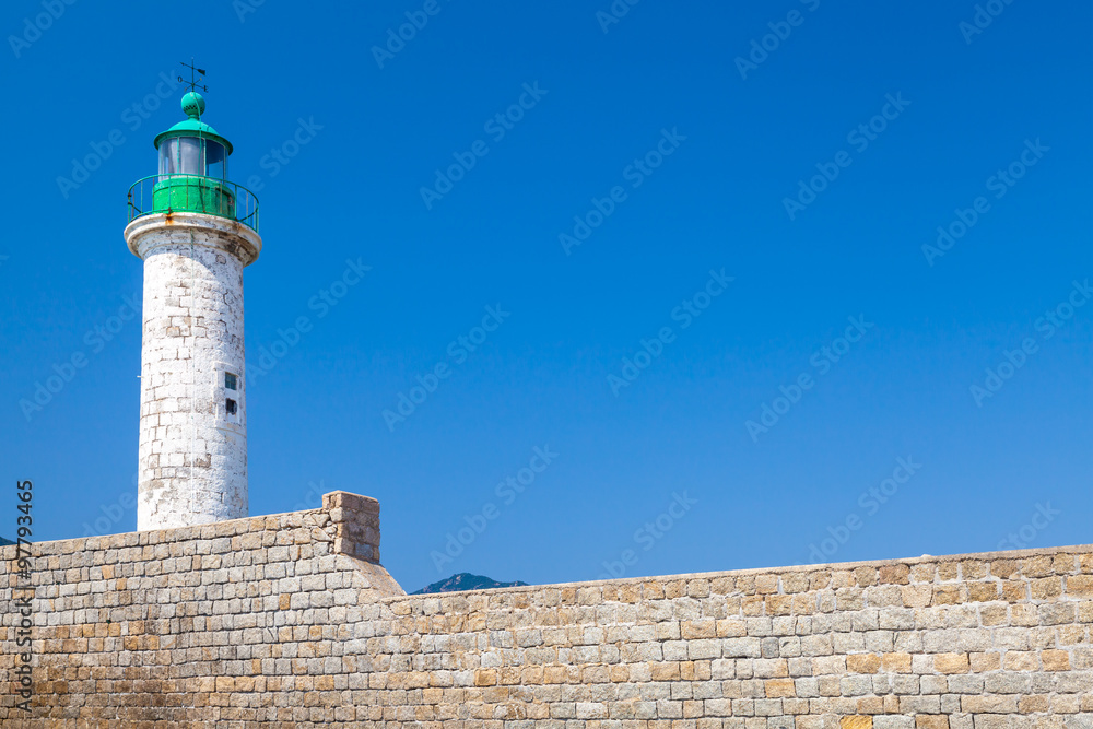 White lighthouse tower on stone pier