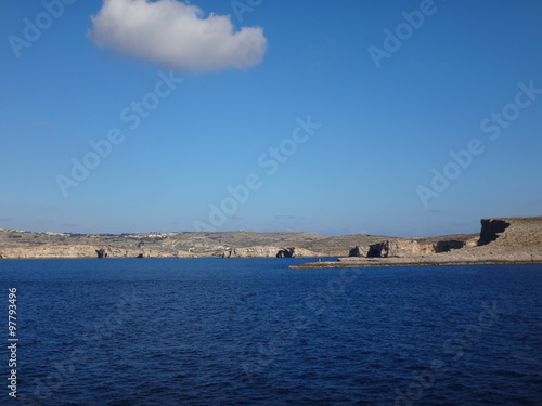Скалистый остров вдали в море под голубым небом © keleny