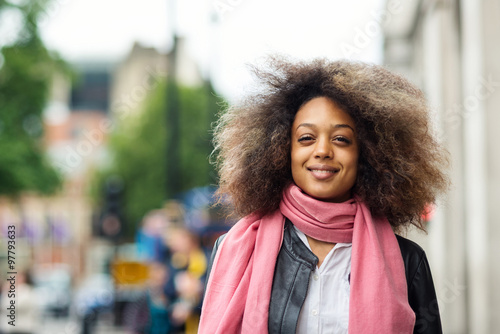 Young smiling woman portrait in the street in London. Filtered image.
