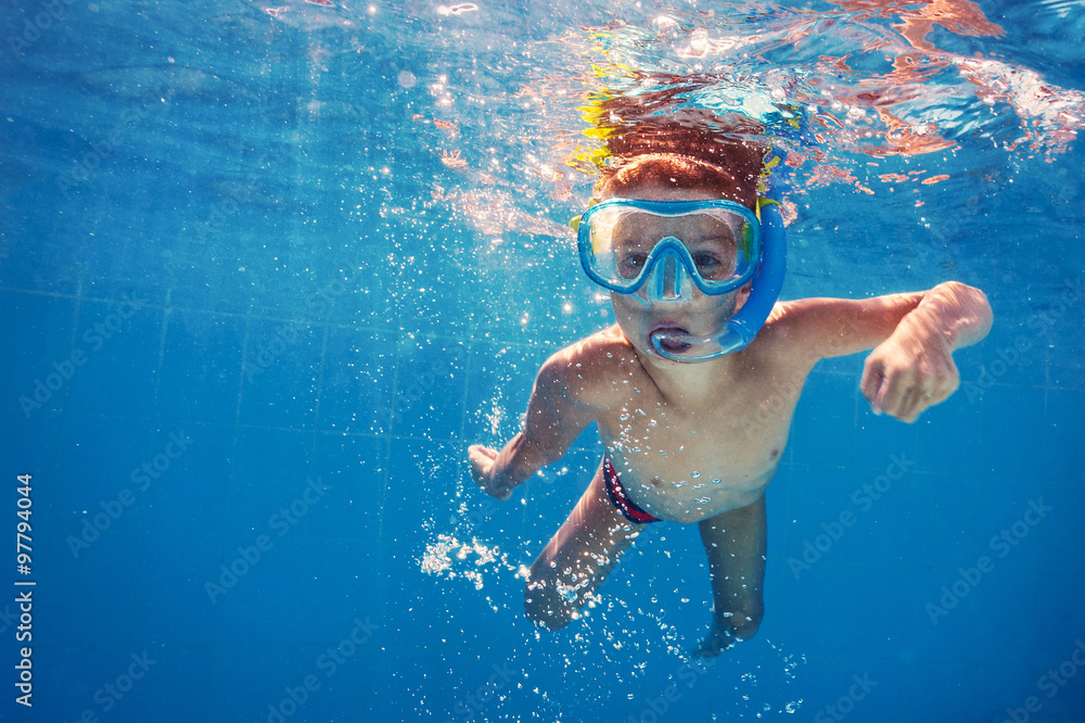 Underwater kid in swimming pool with mask.