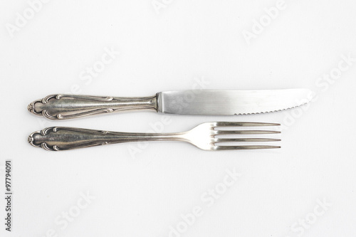 Фотография knife, fork - old fancy silver cutlery set on white background - beautiful sterl