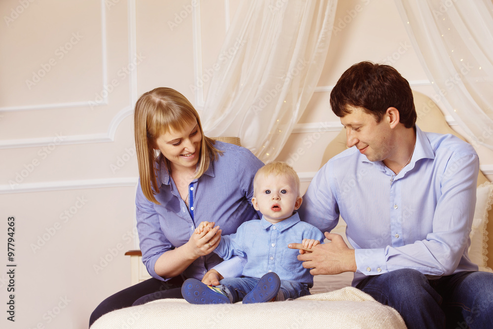 Concept of happy family - father, mother and son are sitting 