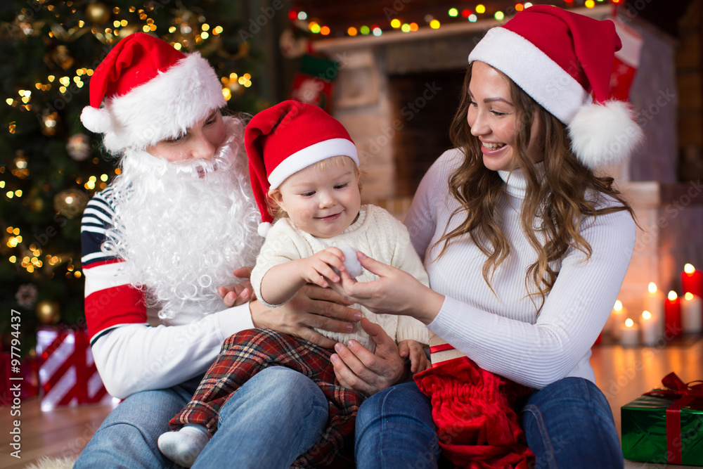 Happy family having a fun near Christmas tree and fireplace in living room Happy family having a fun near Christmas tree and fireplace in living room