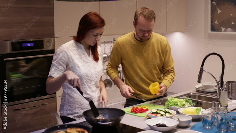 The husband and wife preparing food in kitchen. The husband and wife preparing food in kitchen.