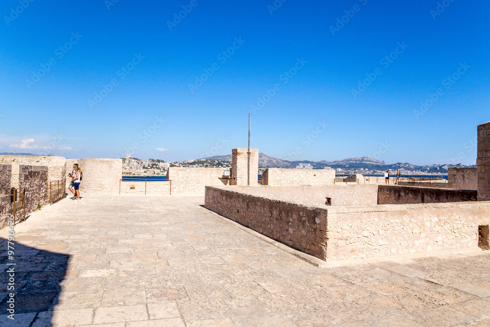 The artillery position of the castle on the island of If. In the background, Marseille