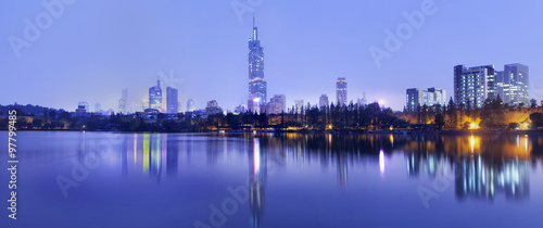 Twilight skyline reflected in calm water, Nanjing, China