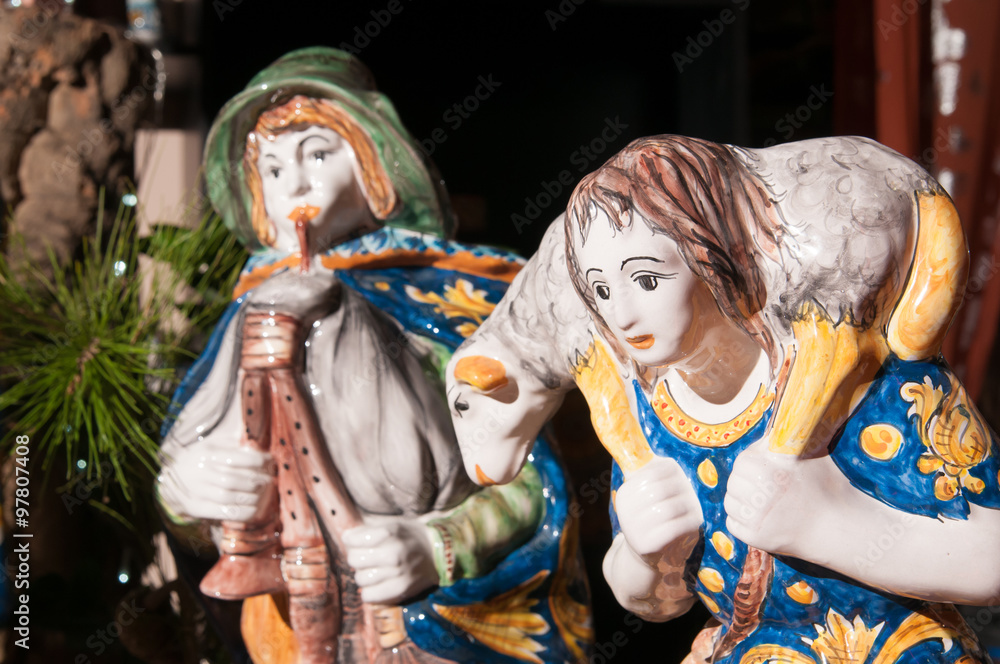 Painted pottery statue portraying a shepherd and his little sheep of a ceramic nativity scene by an artisan in Caltagirone