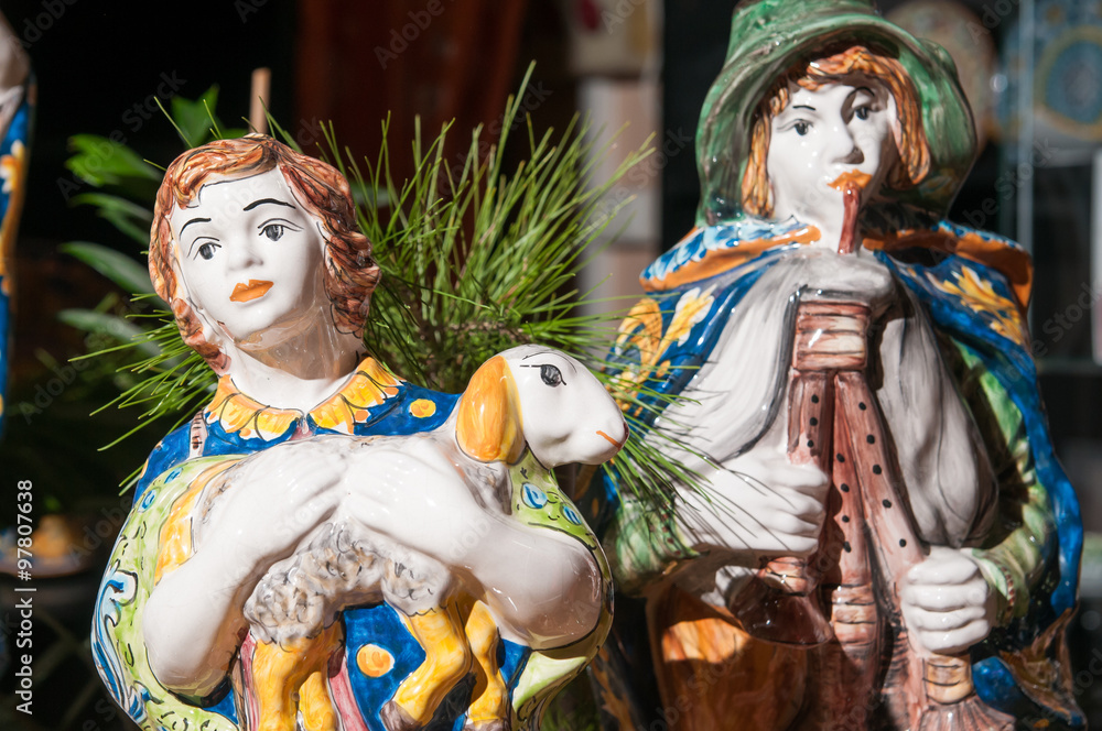 Painted pottery statue portraying a shepherd and his little sheep of a ceramic nativity scene by an artisan in Caltagirone Painted pottery statue portraying a shepherd and his little sheep of a ceramic nativity scene by an artisan in Caltagirone