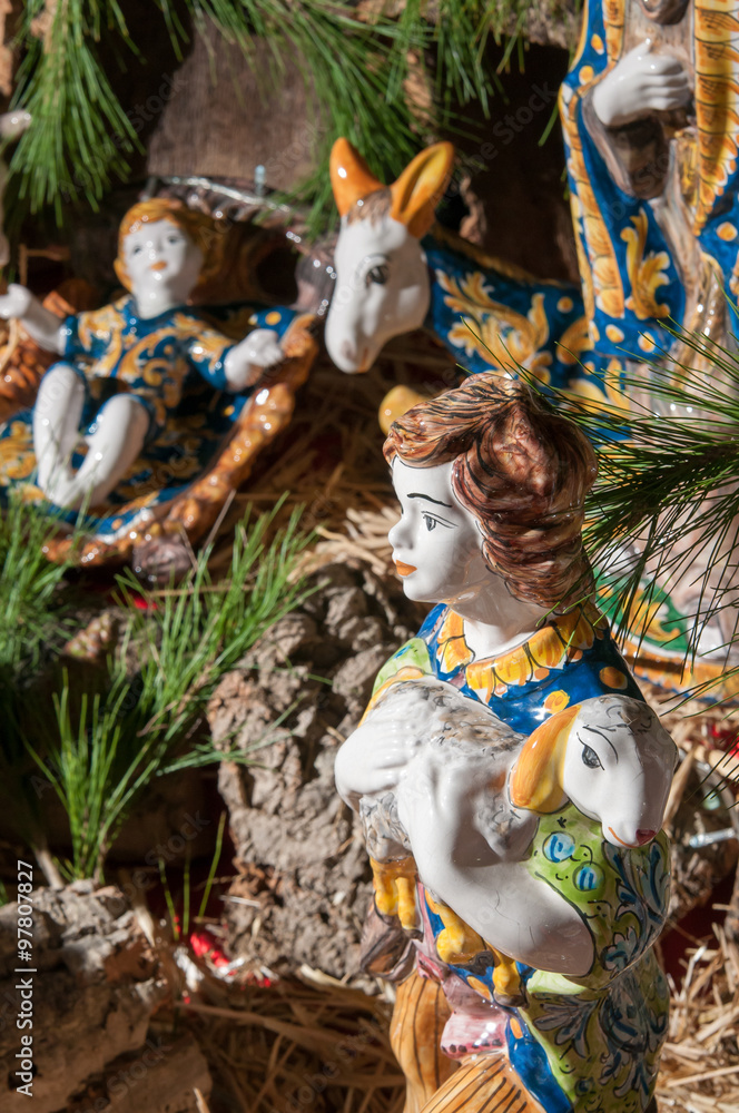 Painted pottery statue portraying a shepherd and his little sheep of a ceramic nativity scene by an artisan in Caltagirone