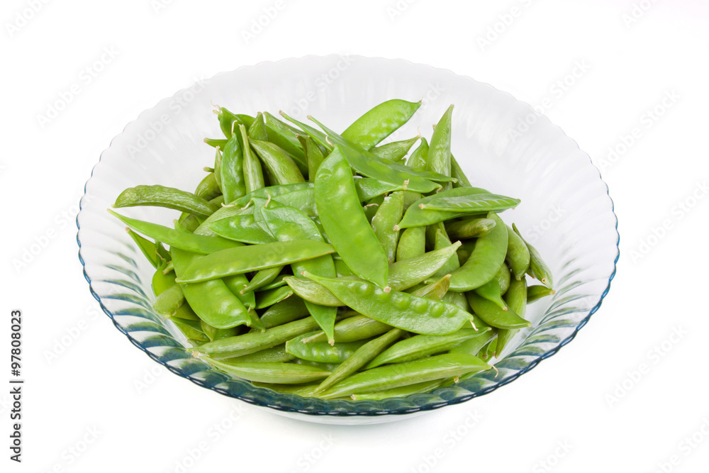 Bowl of Snow Peas on White Background – A bowl of fresh snow peas in a blue glass bowl. White background. Bowl of Snow Peas on White Background – A bowl of fresh snow peas in a blue glass bowl. White background.