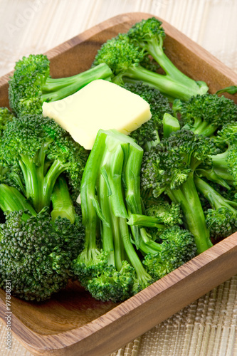 Broccoli with Butter – Fresh steamed broccoli, topped with a pat of butter, in a wooden bowl.