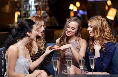 woman showing engagement ring to her friends