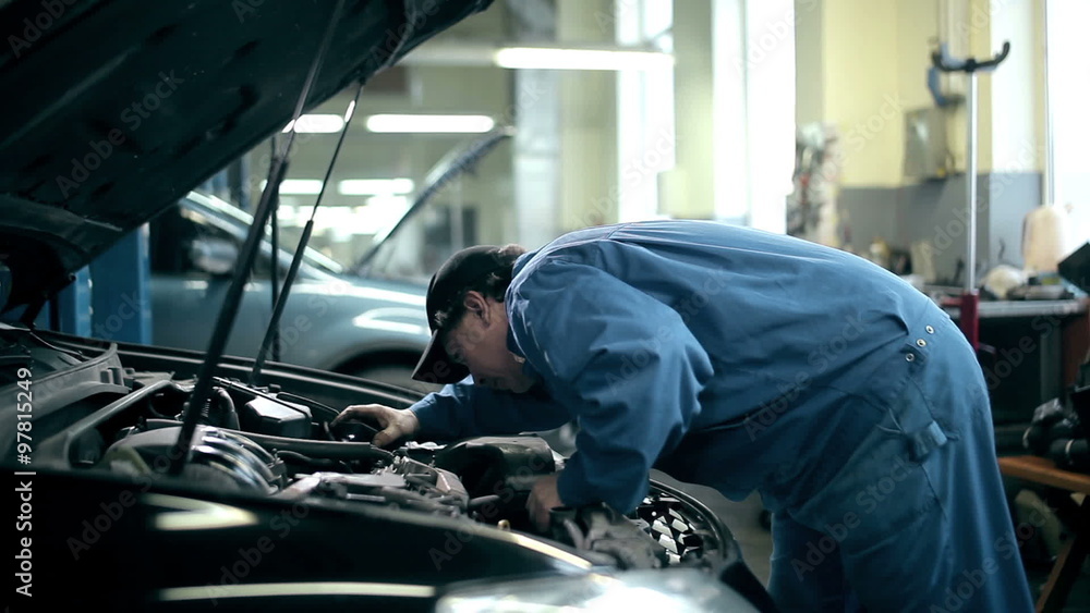 Mechanic inspecting the car engine Mechanic inspecting the car engine
