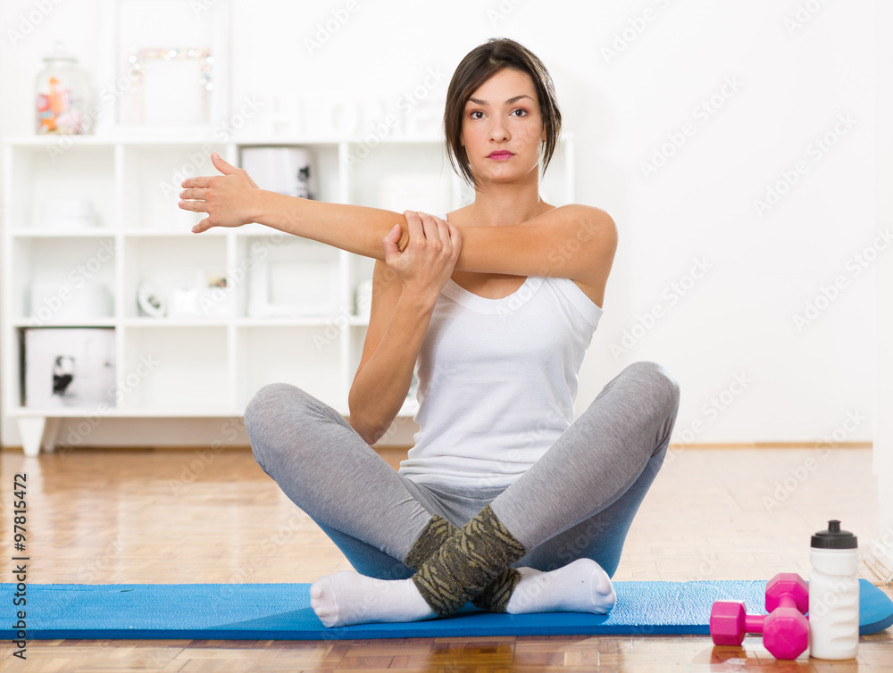 Beautifull young woman stretching on a flor mat before work out Beautifull young woman stretching on a flor mat before work out