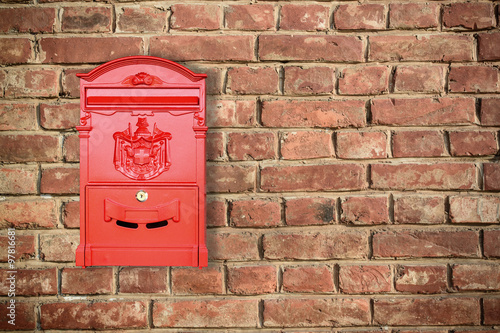 Red mailbox with old brick wall background with copy space