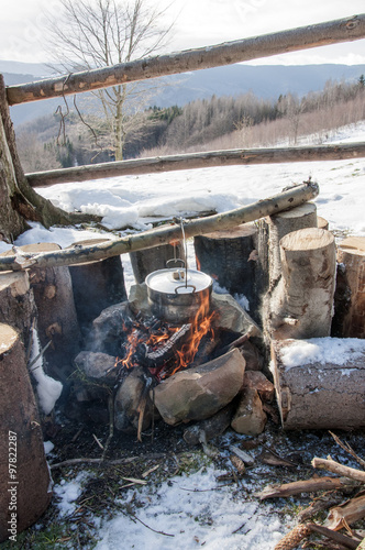 Cooking in field conditions, boiling pot at the campfire on picn photo
