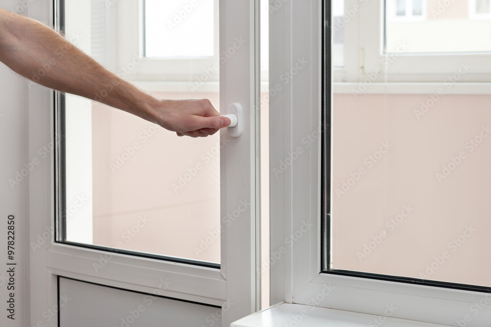 Obraz premium The human hand close a plastic vinyl door.
