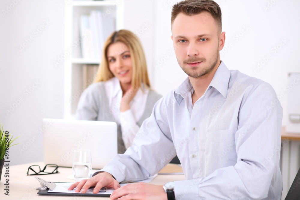 Successful businesspeople working at meeting in office. Businessman looking at camera. Start up business concept. Successful businesspeople working at meeting in office. Businessman looking at camera. Start up business concept.