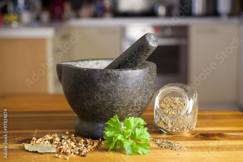 Stone grinder, spices and fresh parsley
