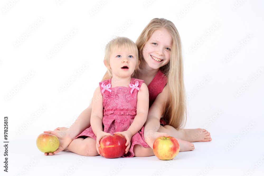 Fototapeta premium adorable little two sisters 9 year and 1 year old with apple o
