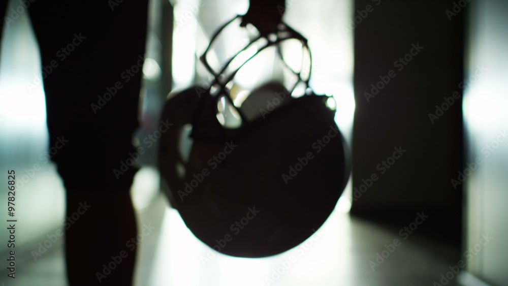  American football player walks alone through stadium tunnel