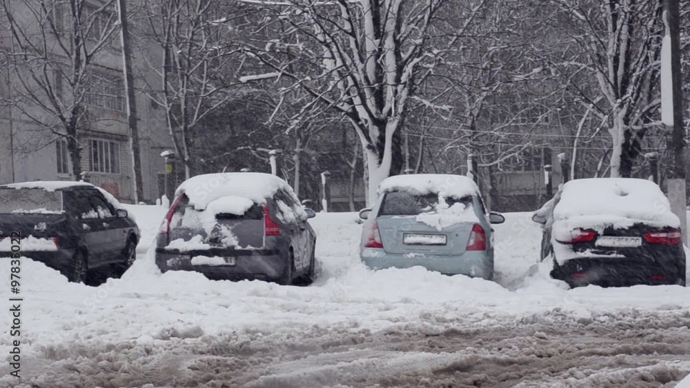 Snow-covered cars parked in a snow storm Snow-covered cars parked in a snow storm