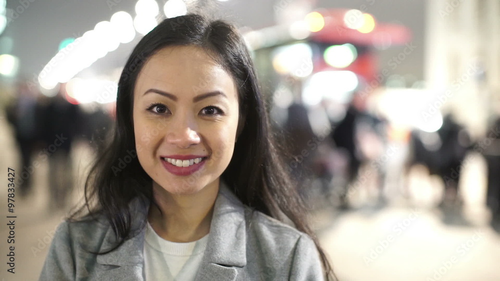 Portrait of smiling professional woman in city at night with crowds and traffic Portrait of smiling professional woman in city at night with crowds and traffic
