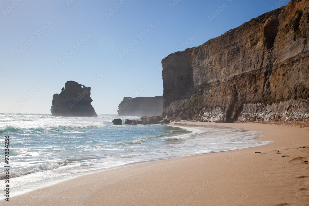 Sandy beach with massive limestone cliffs in background on the s Sandy beach with massive limestone cliffs in background on the s