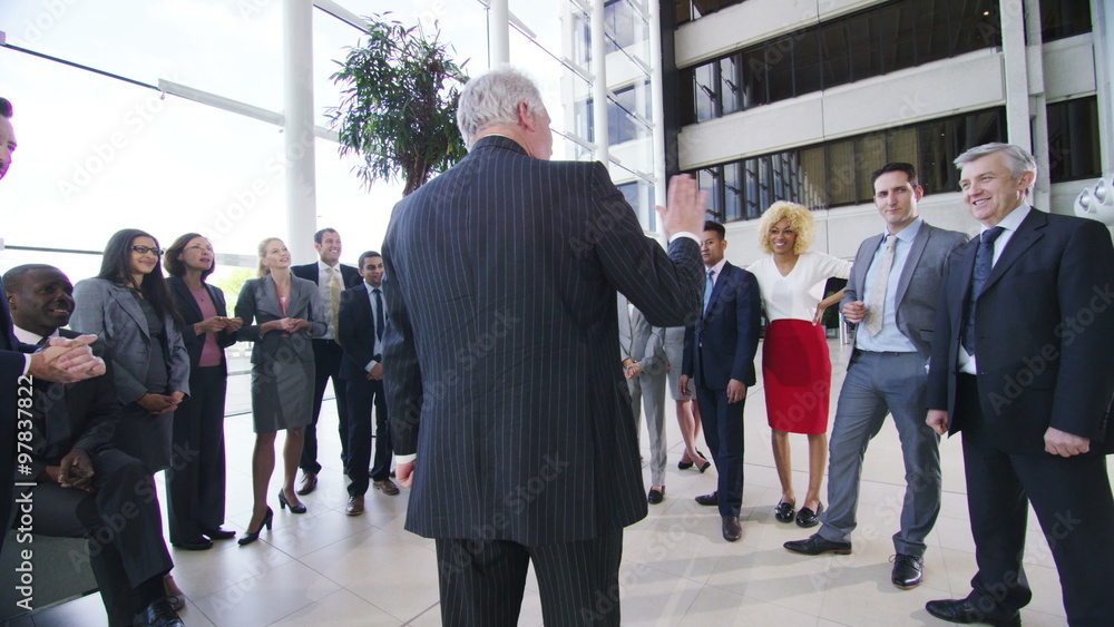 Confident diverse business team applauding their success and shaking hands Confident diverse business team applauding their success and shaking hands