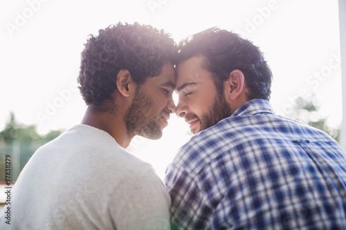 Happy gay couple sitting outdoors photo