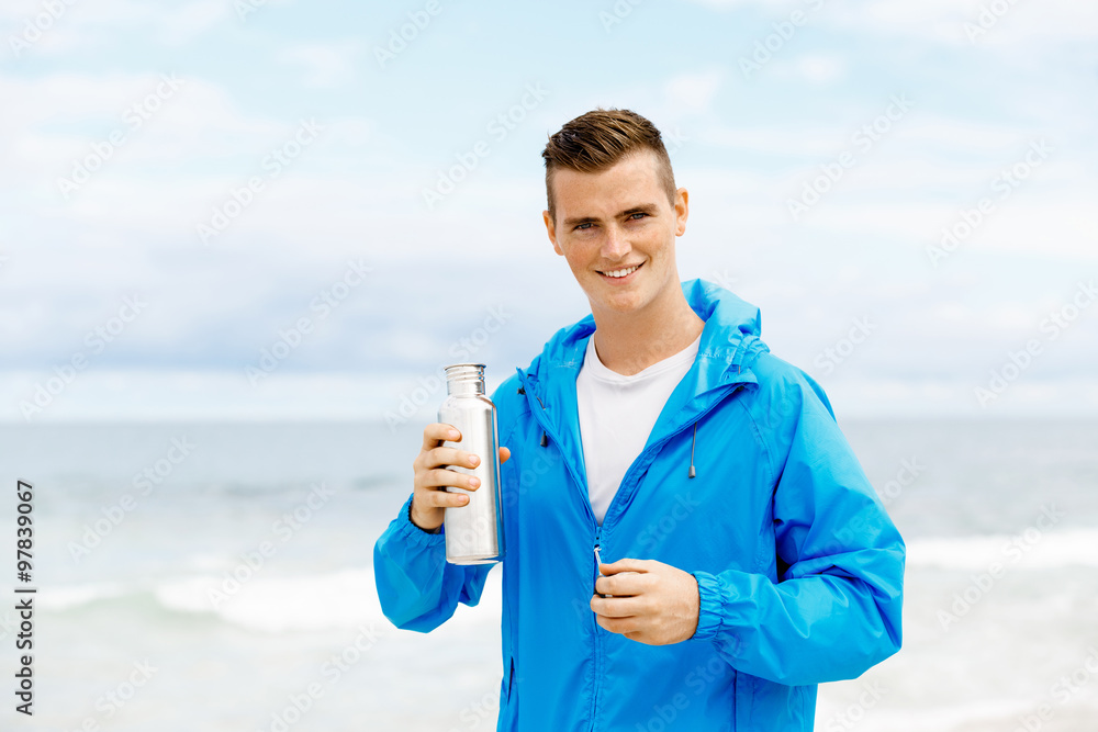 Confident young man holding bottle with water Confident young man holding bottle with water