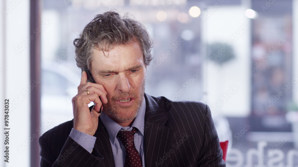 Depressed businessman hangs up someone during phone conversation Depressed businessman hangs up someone during phone conversation