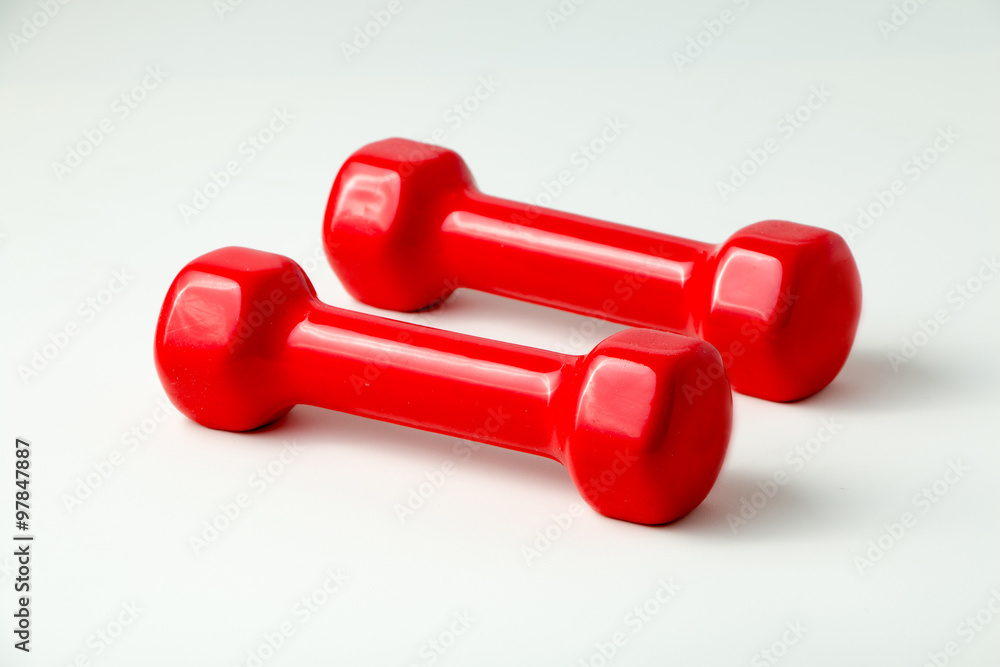 Two red dumbbells isolated on white background Two red dumbbells isolated on white background