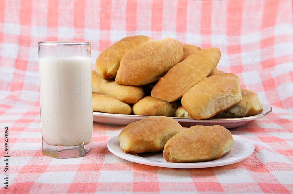 Naklejka premium glass of milk and cakes on a plate